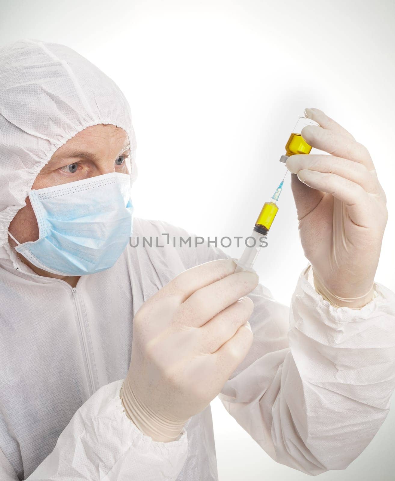 Man with syringe and vial in protective suit and mask