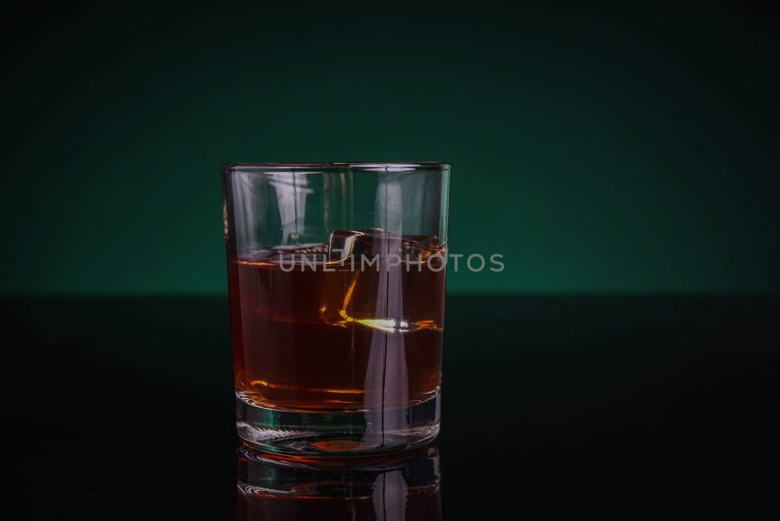 A glass of whisky or rum, with green backlight