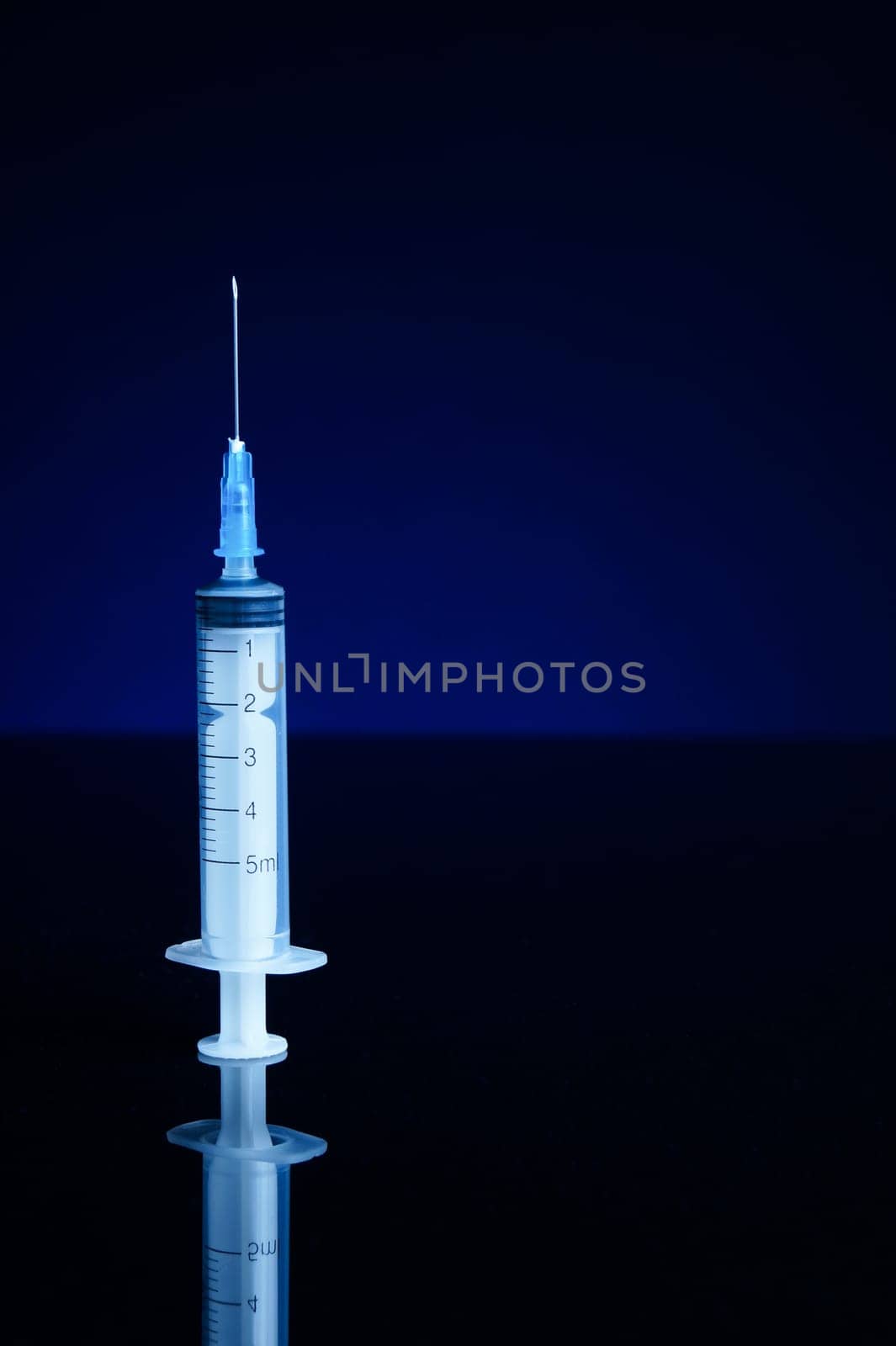 Syringe, isolated on black and blue background