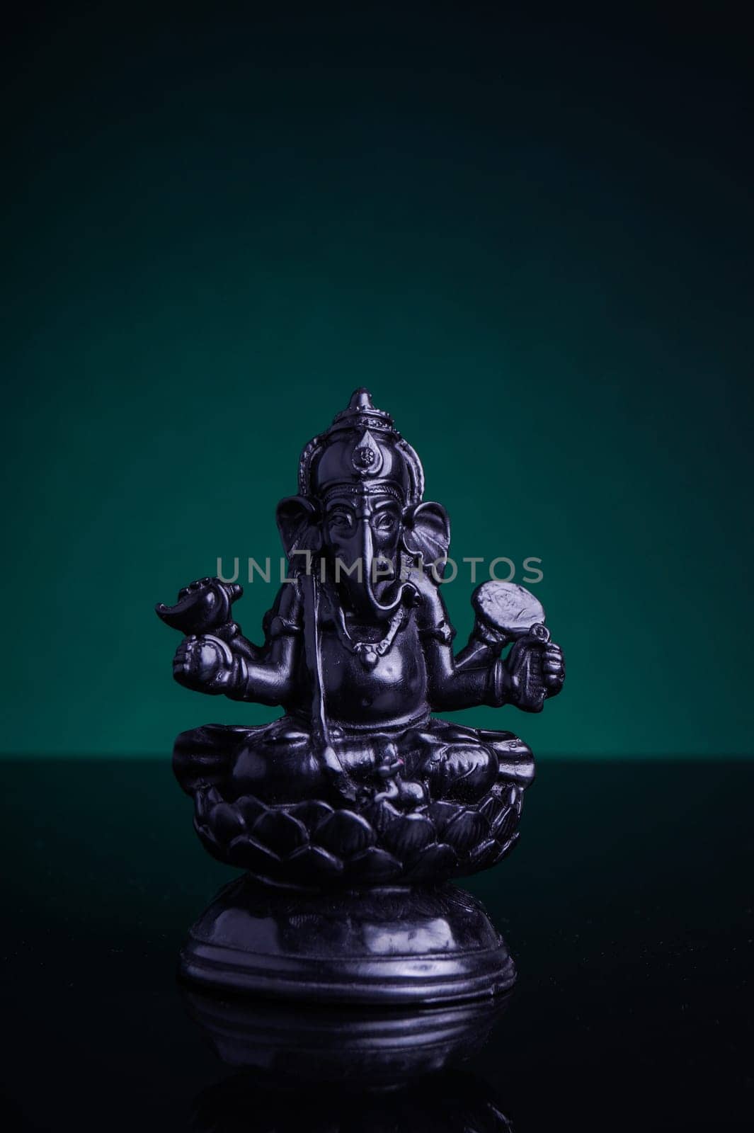 Statue of the Hindu God Ganesha with green background