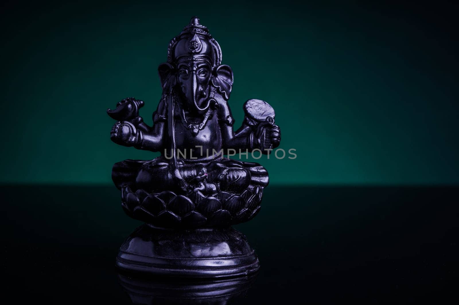 Statue of the Hindu God Ganesha with green background