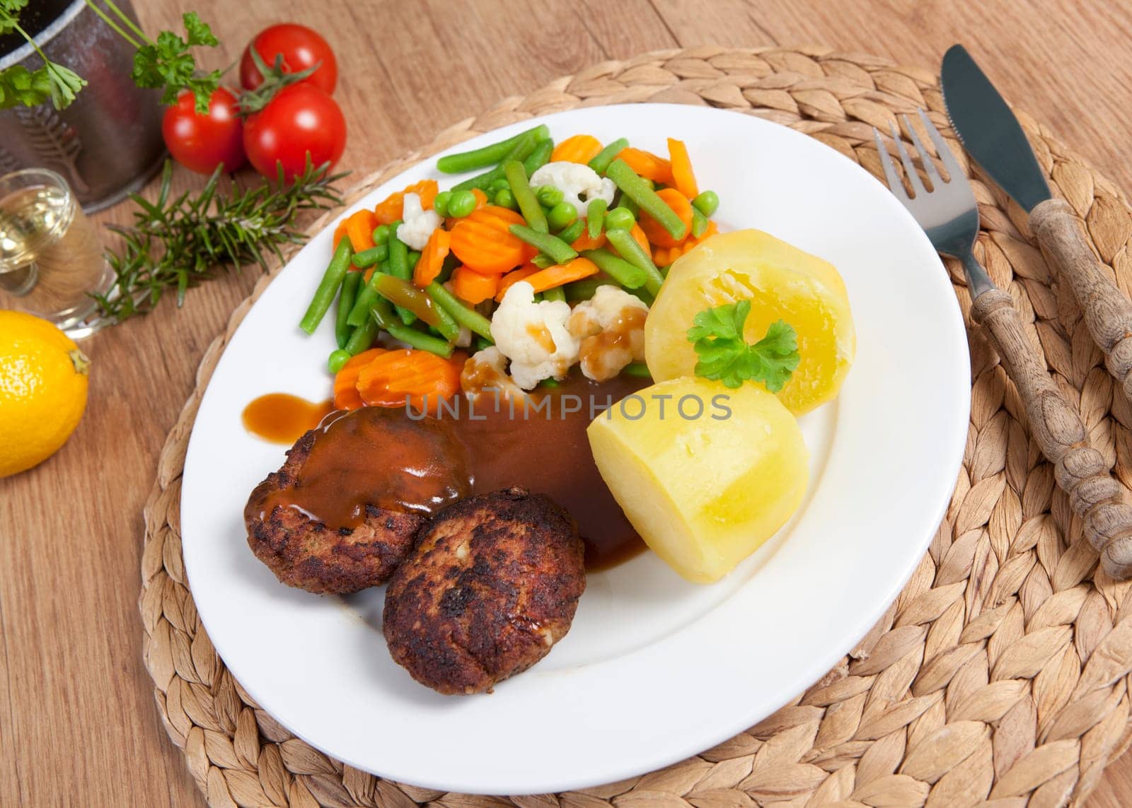 fried meatballs on a plate of vegetables and potatoes