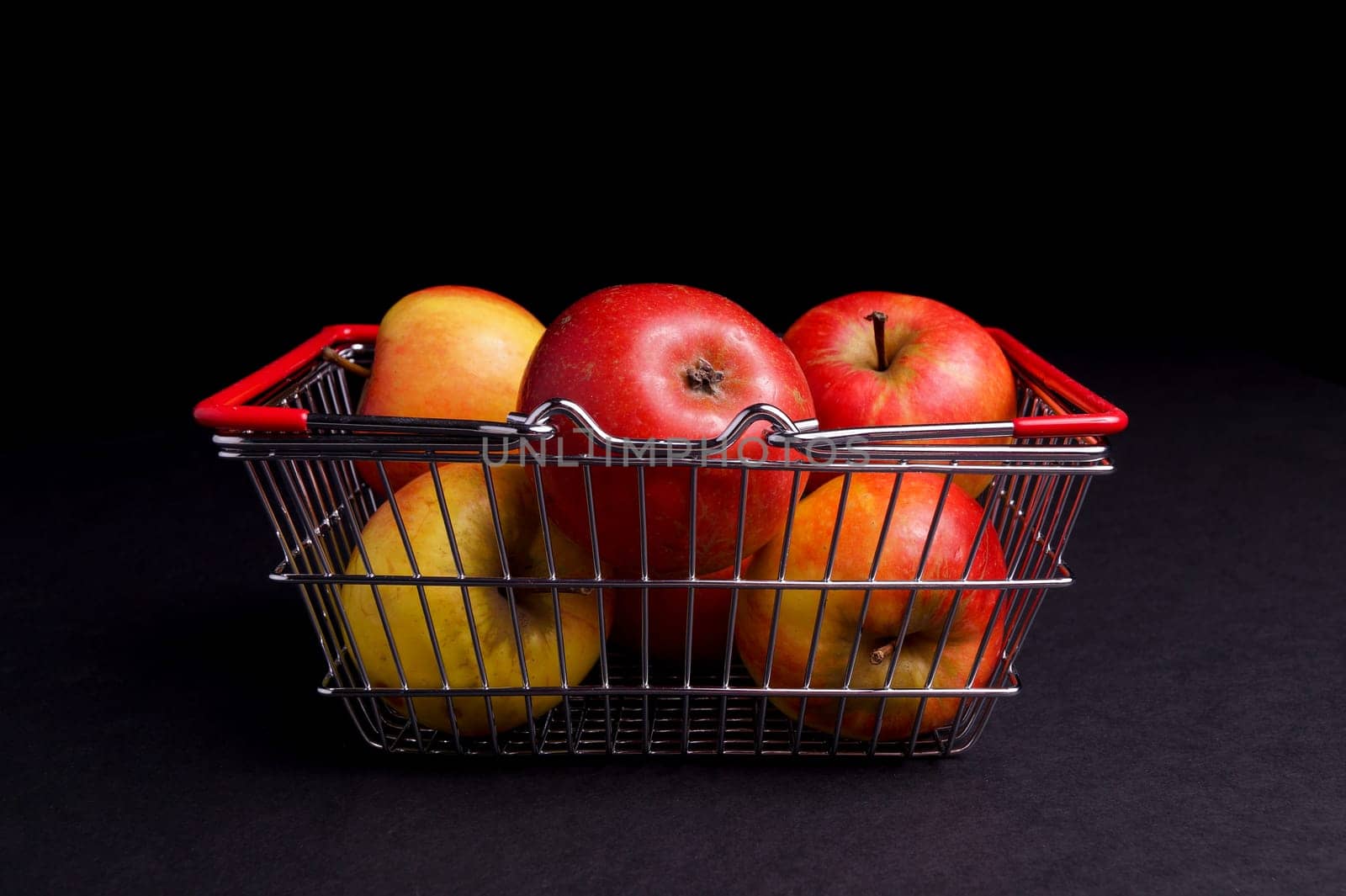 Basket of ripe red apples isolated on Black