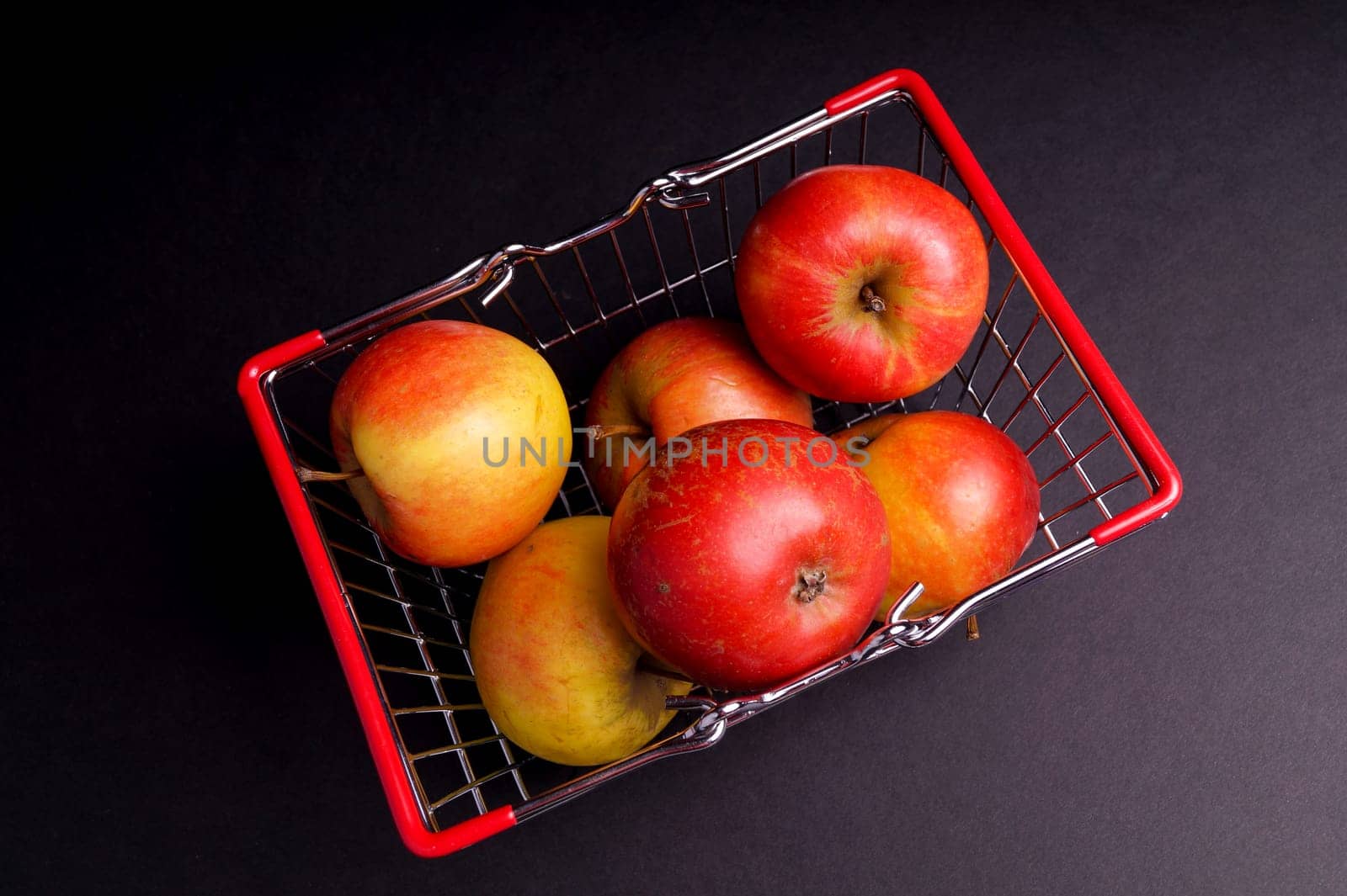 Basket of ripe red apples isolated on Black