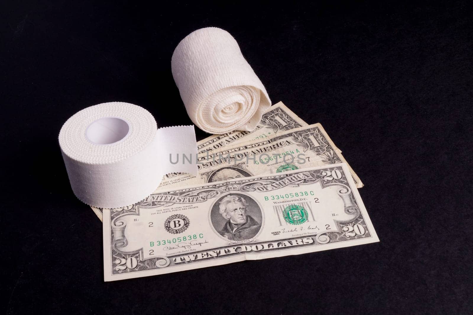 Therapeutic self adhesive tape for, aches and tension lying with money, isolated on Black