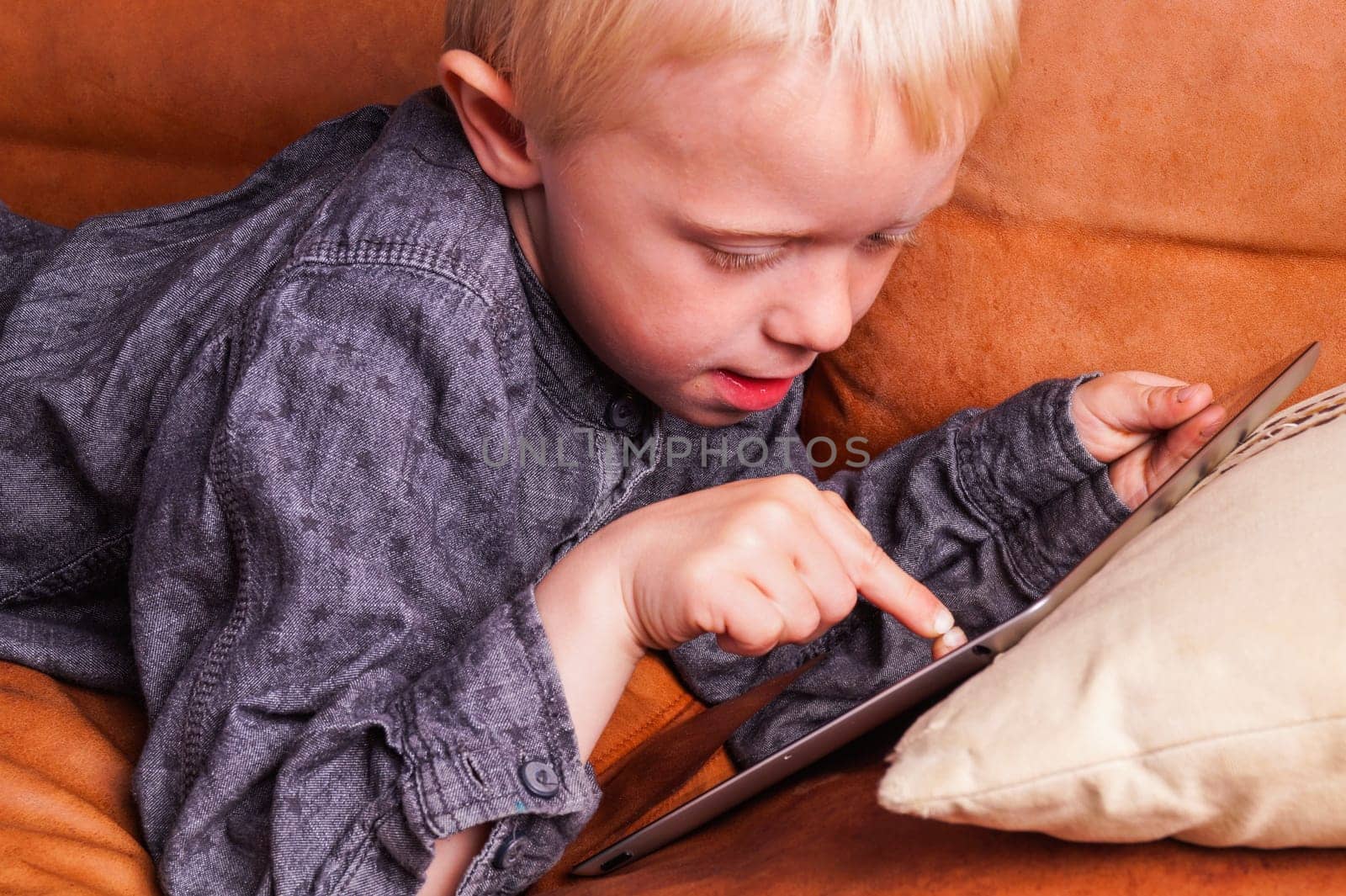 Child with Digital tablet. The Boy play and learn when he is using the tablet
