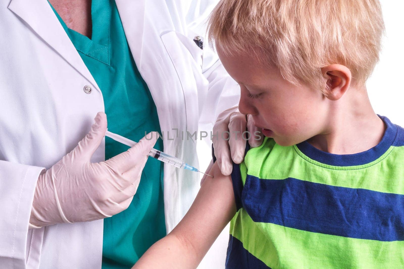 little boy given an injection by the family doctor. The female doctor gives the child an injection in the upper arm. It can be both a vaccination or as part of the boy's medical treatment