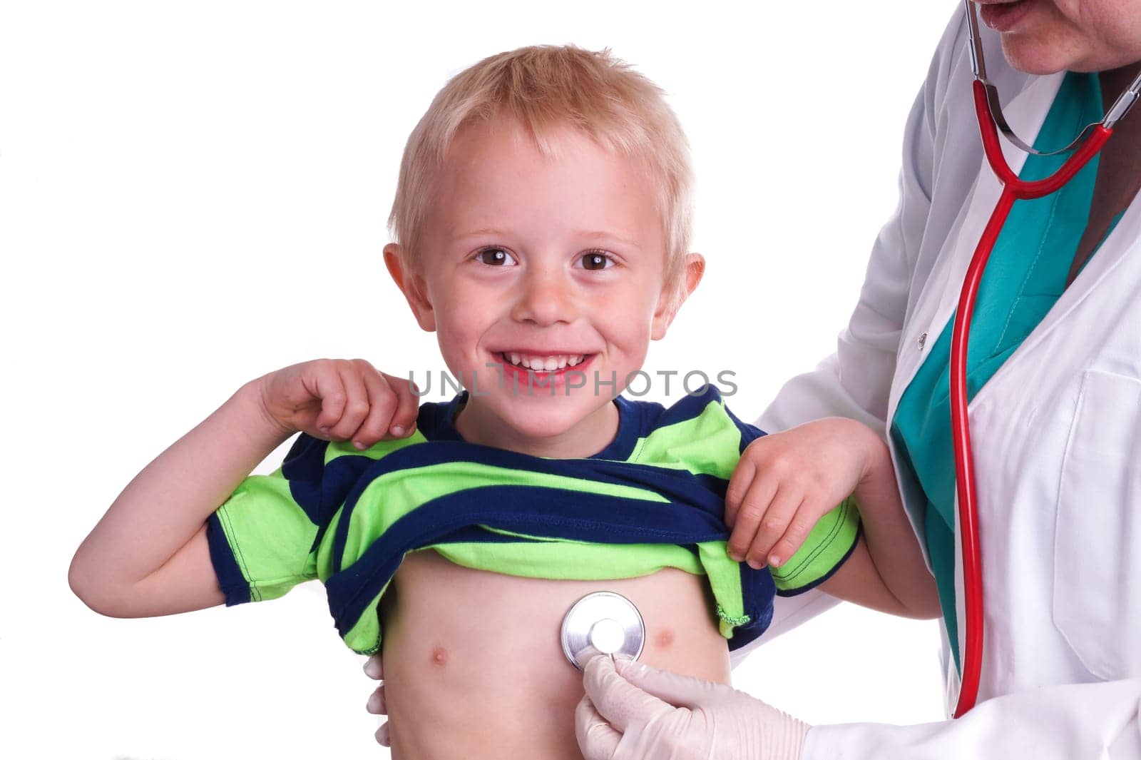 Doctor examines a young child. The doctor examines the child and listening to the heart and lungs with her stethoscope. He helps doctor by lift his shirt up so the nurse can come to listen to the boy's chest
