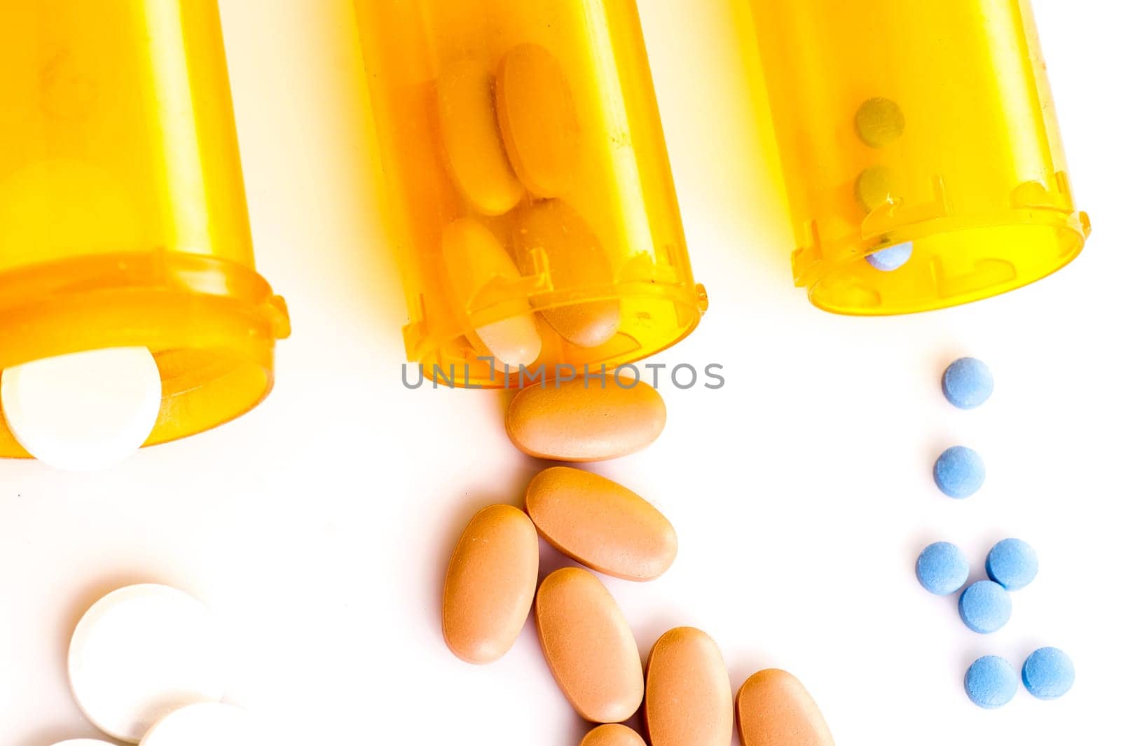 Pill Medicine, white, blue and brown pills lying with the medicine bottle, isolated on white