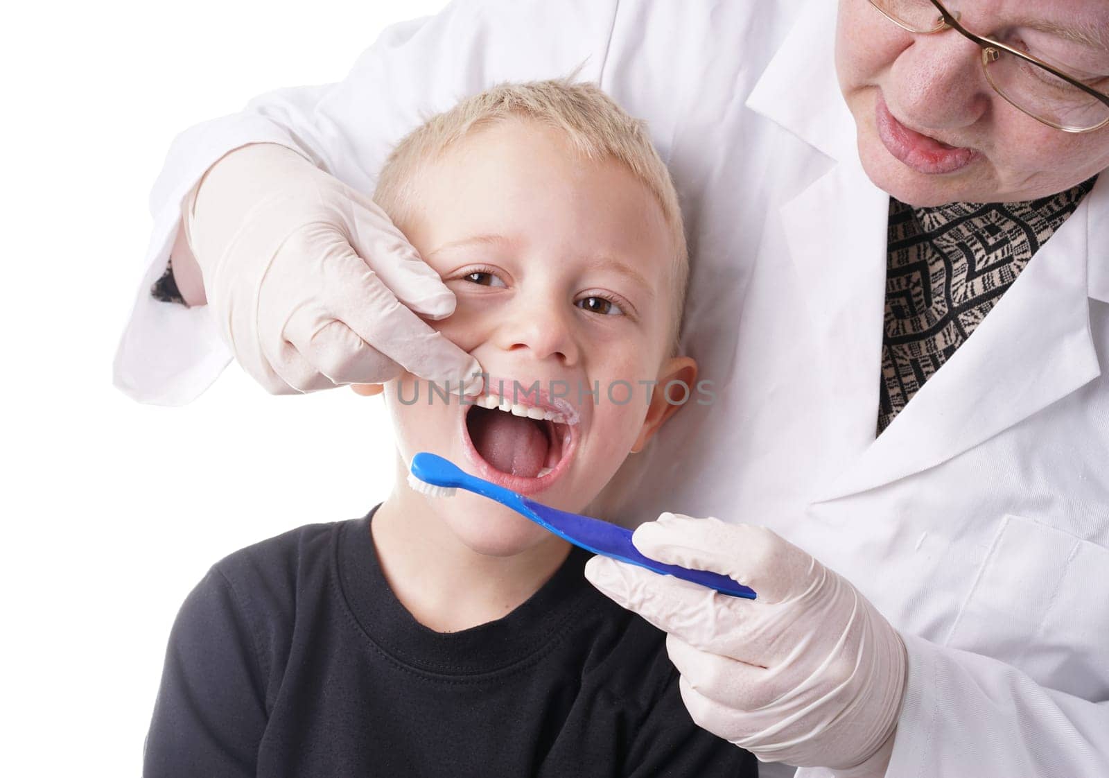 Young Boy gets help by the Dentist to brush his teeth, Isolated on white