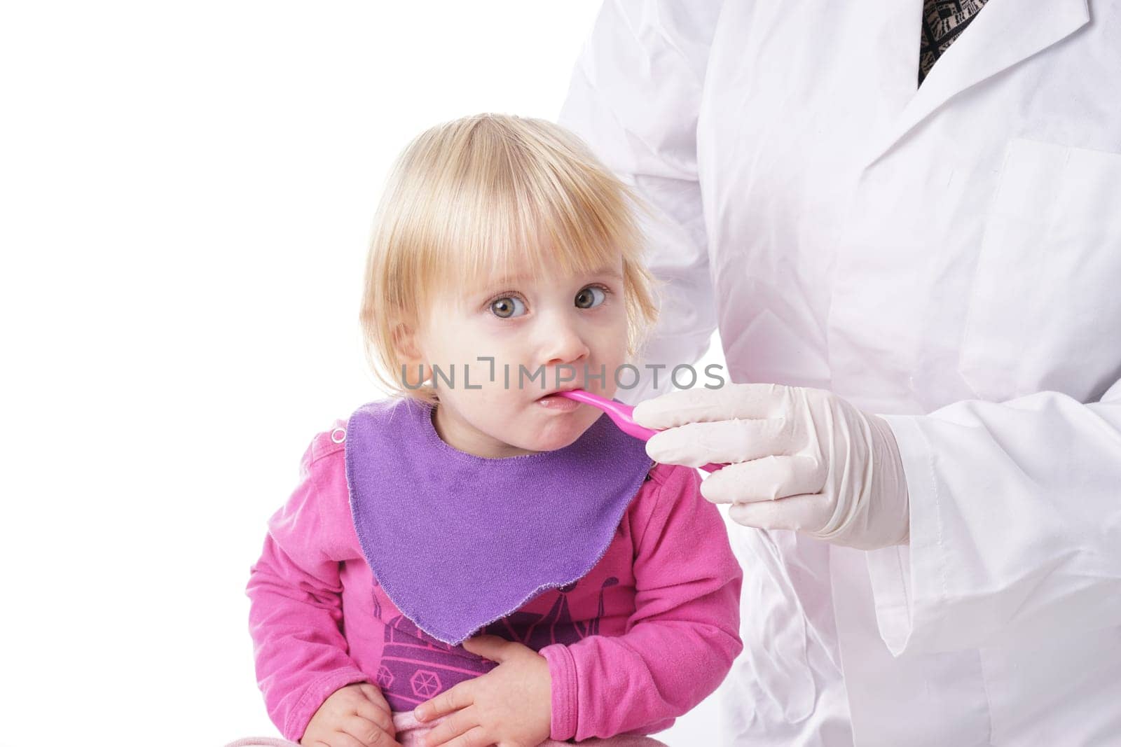 Baby girl gets help by the Dentist to brush his teeth, Isolated on white