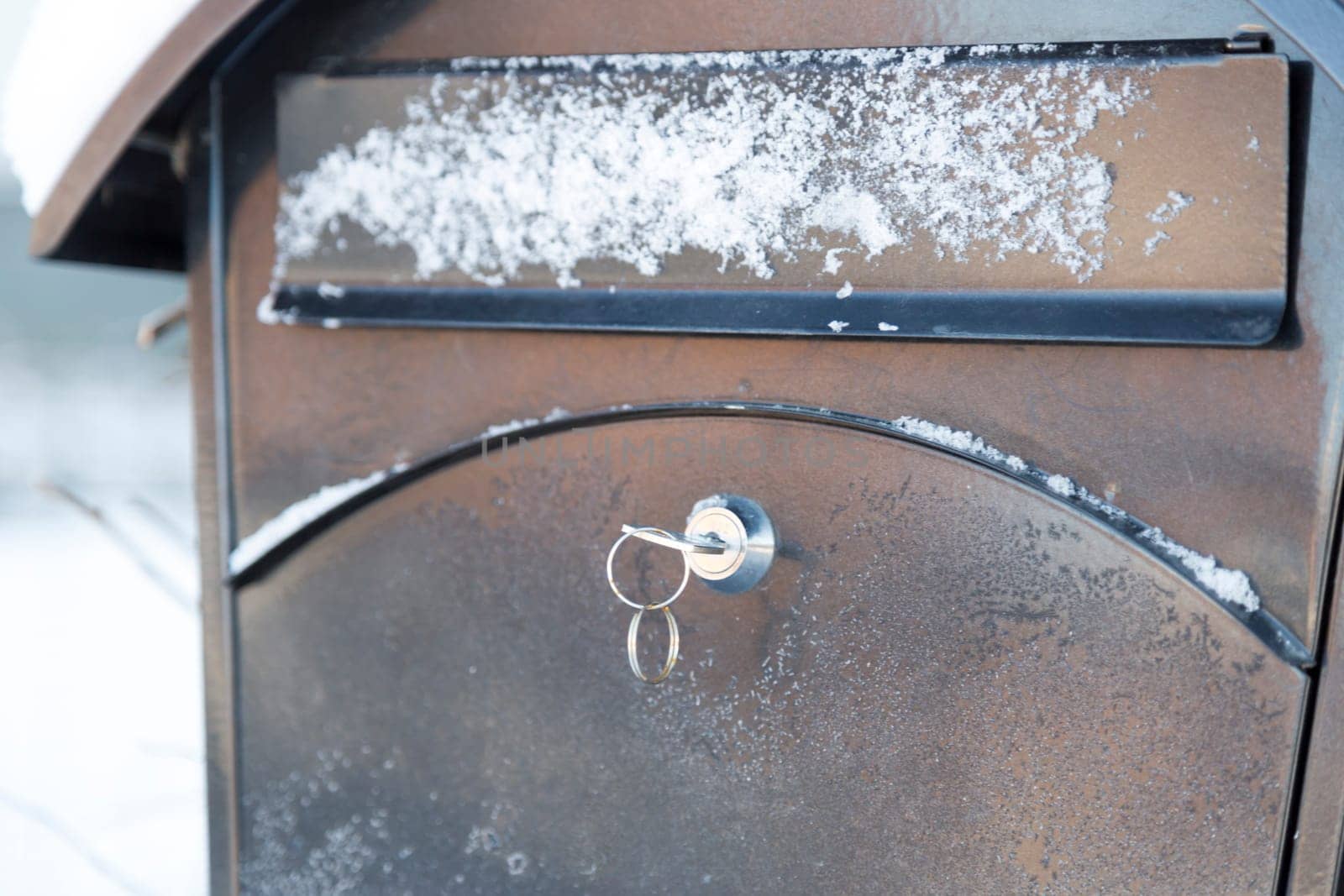 Key in black Letter Box with snow and frost.