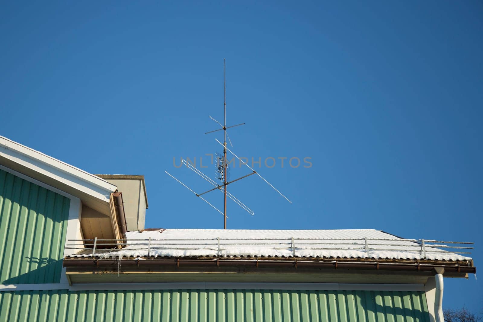 TV Antenna on Snow Covered Roof.