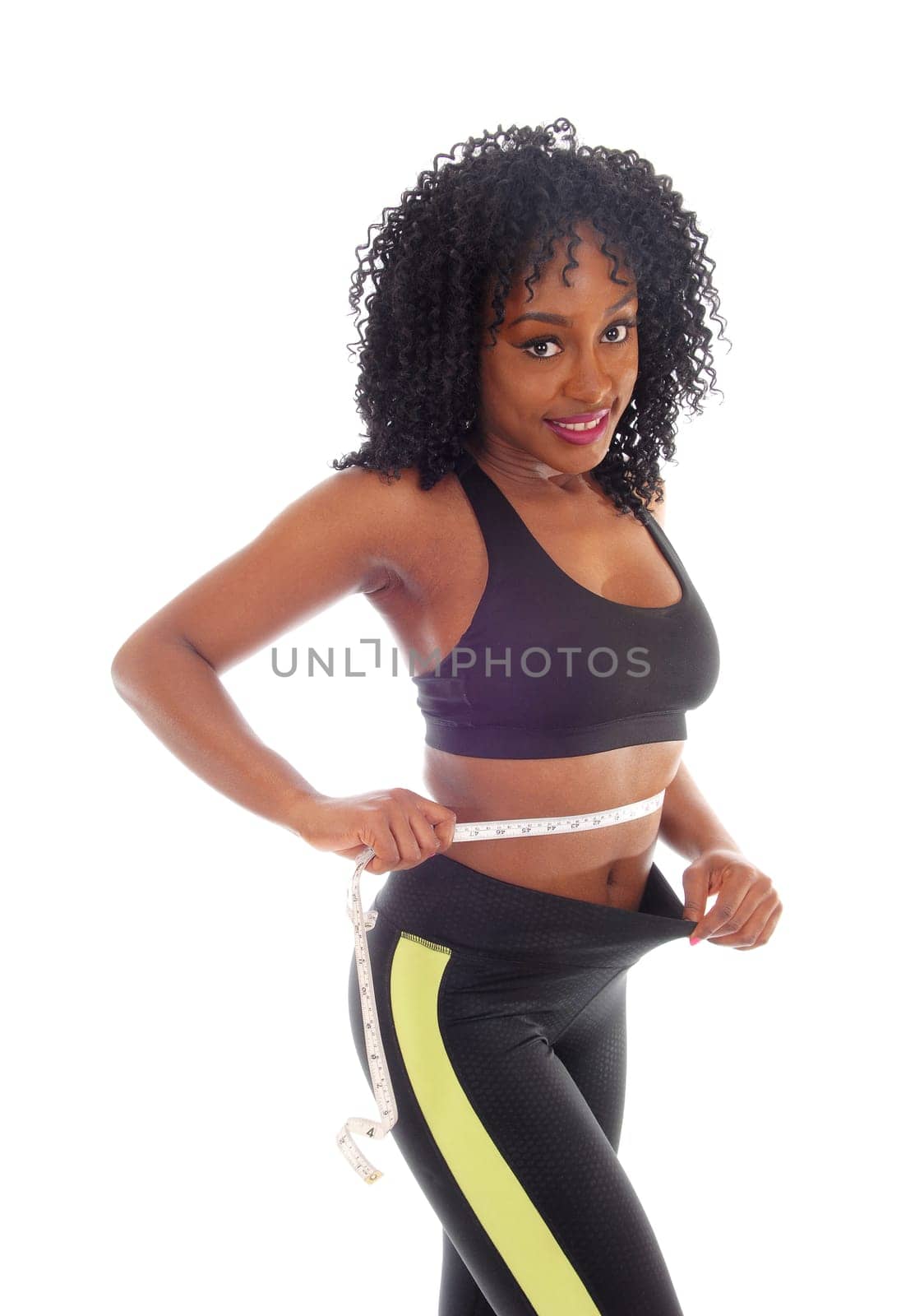 A lovely young African American woman measuring her waist in exercise.outfit and curly black hair, isolated for white background..