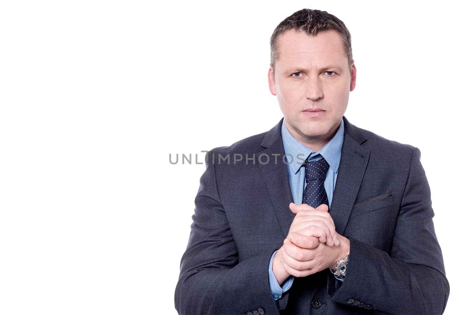 Serious businessman with clasped hands over white