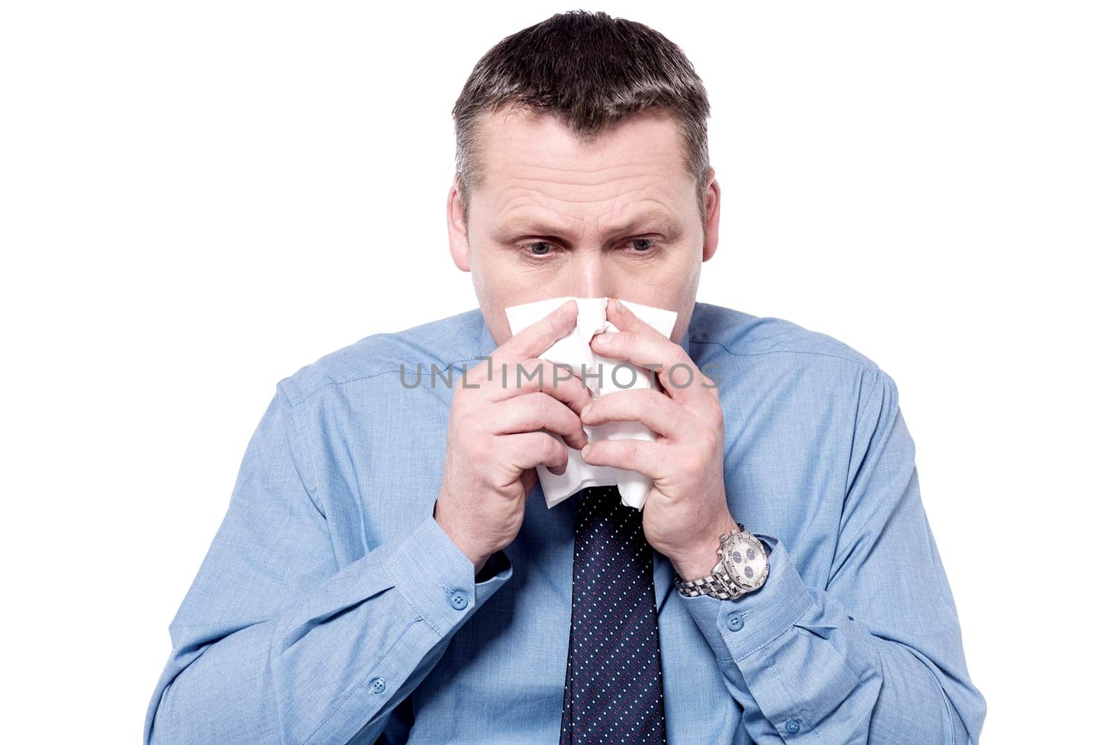 Sick businessman blowing his nose into a tissue