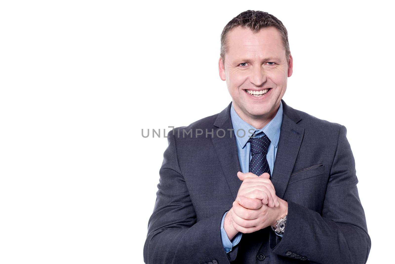 Cheerful businessman posing with his hands clasped