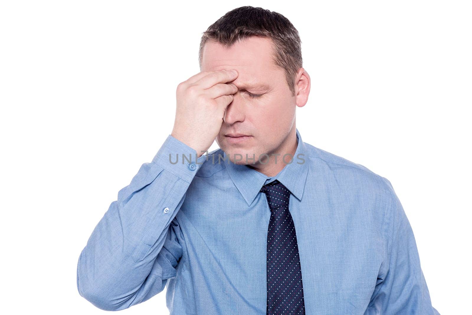 Depressed corporate executive keeping his hand on forehead