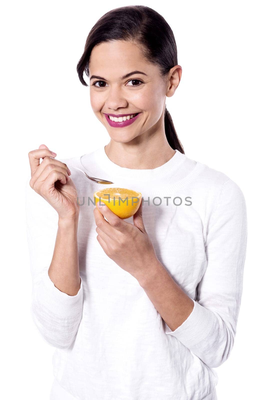 Woman eating an orange, using spoon.