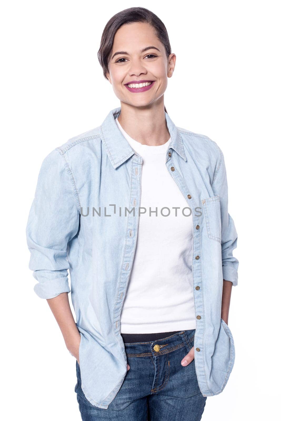 Attractive young woman with hands in pockets over white
