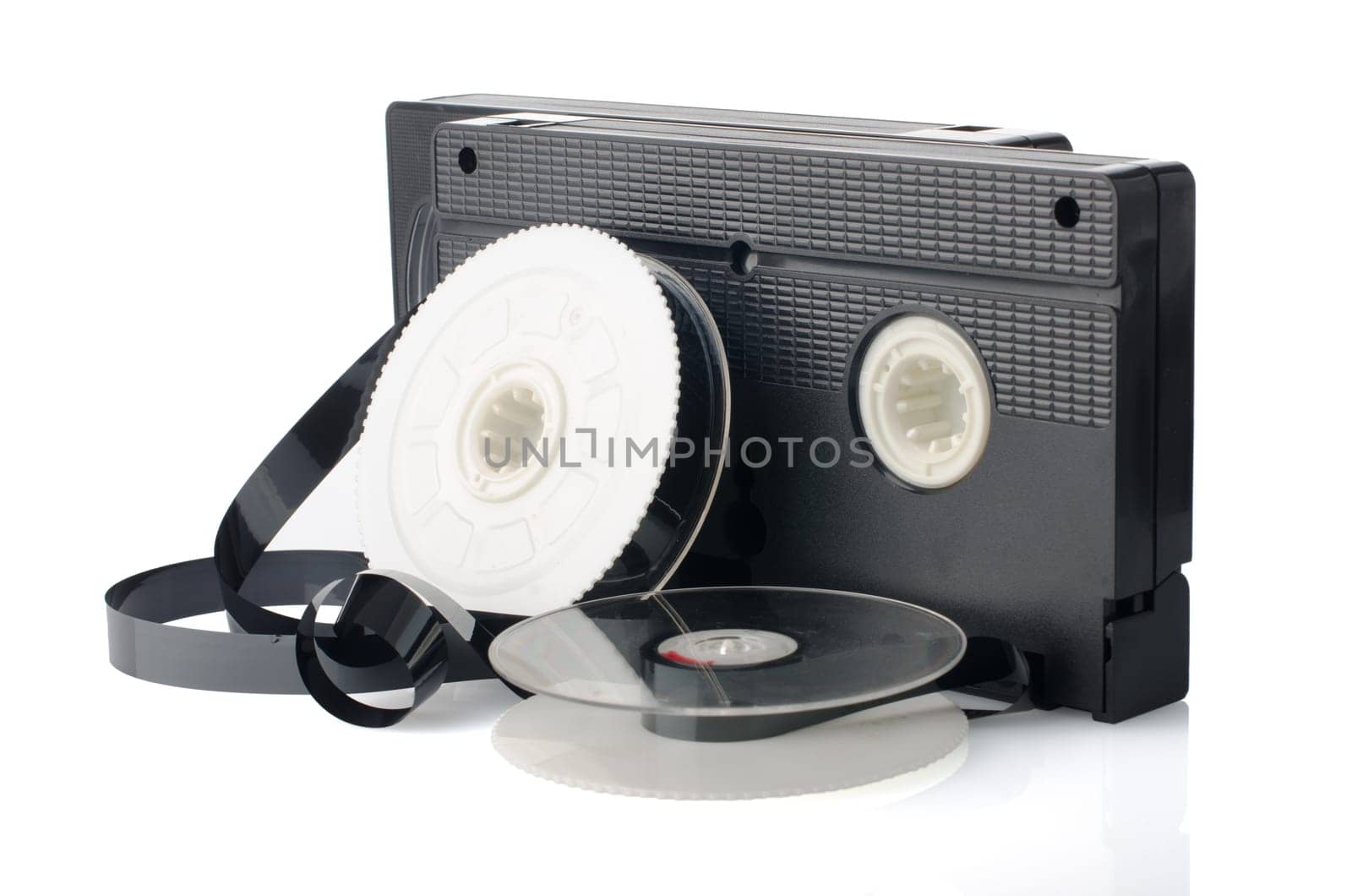 Two videotapes and reel on  white reflective background.
