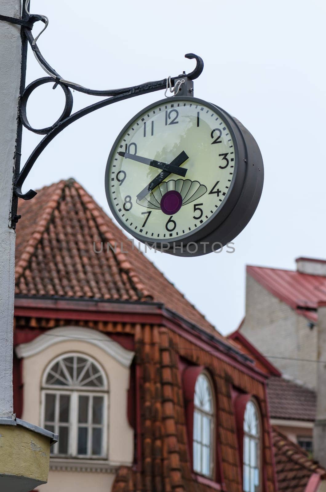 The town clock on the background of tiled roofs of Tallinn, close-up