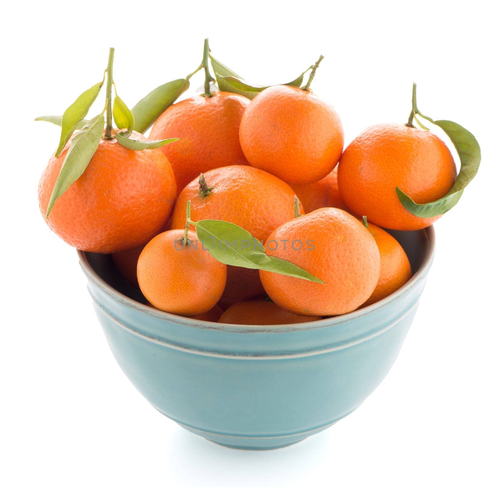 Tangerines on ceramic blue bowl  isolated on white background
