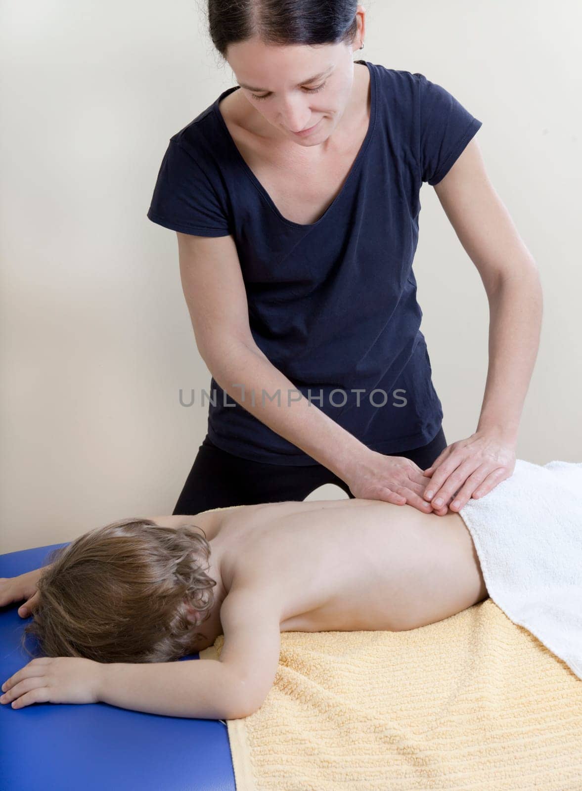 a female physiotherapist makes physiotherapy with young children