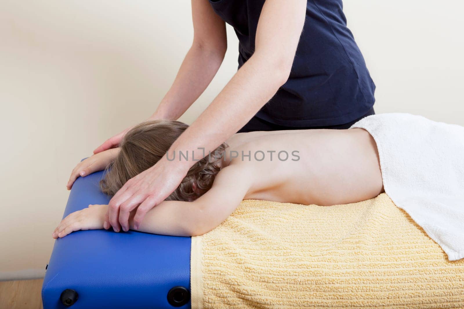 a female physiotherapist makes physiotherapy with young children