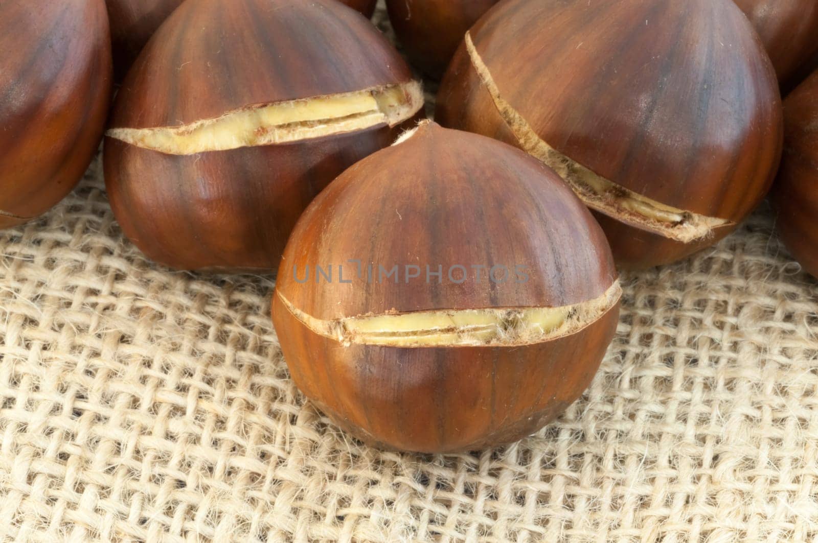 raw natural macro of chestnuts in jute background