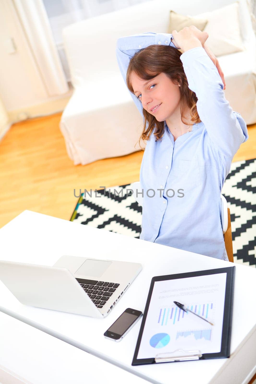 View of a young smiling business woman relaxing at work