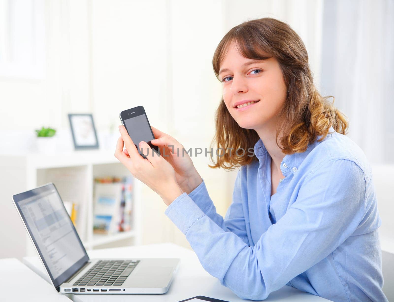 View of a young business woman writing a text on her mobile