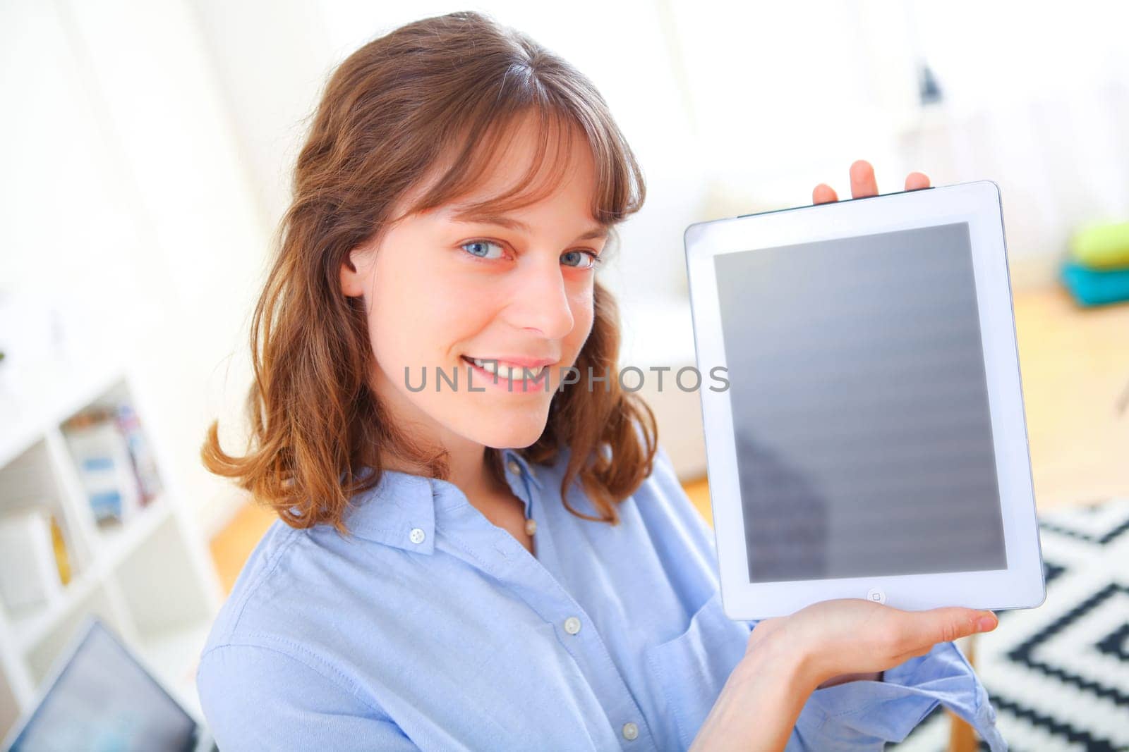 View of a young business woman showing a tablet screen