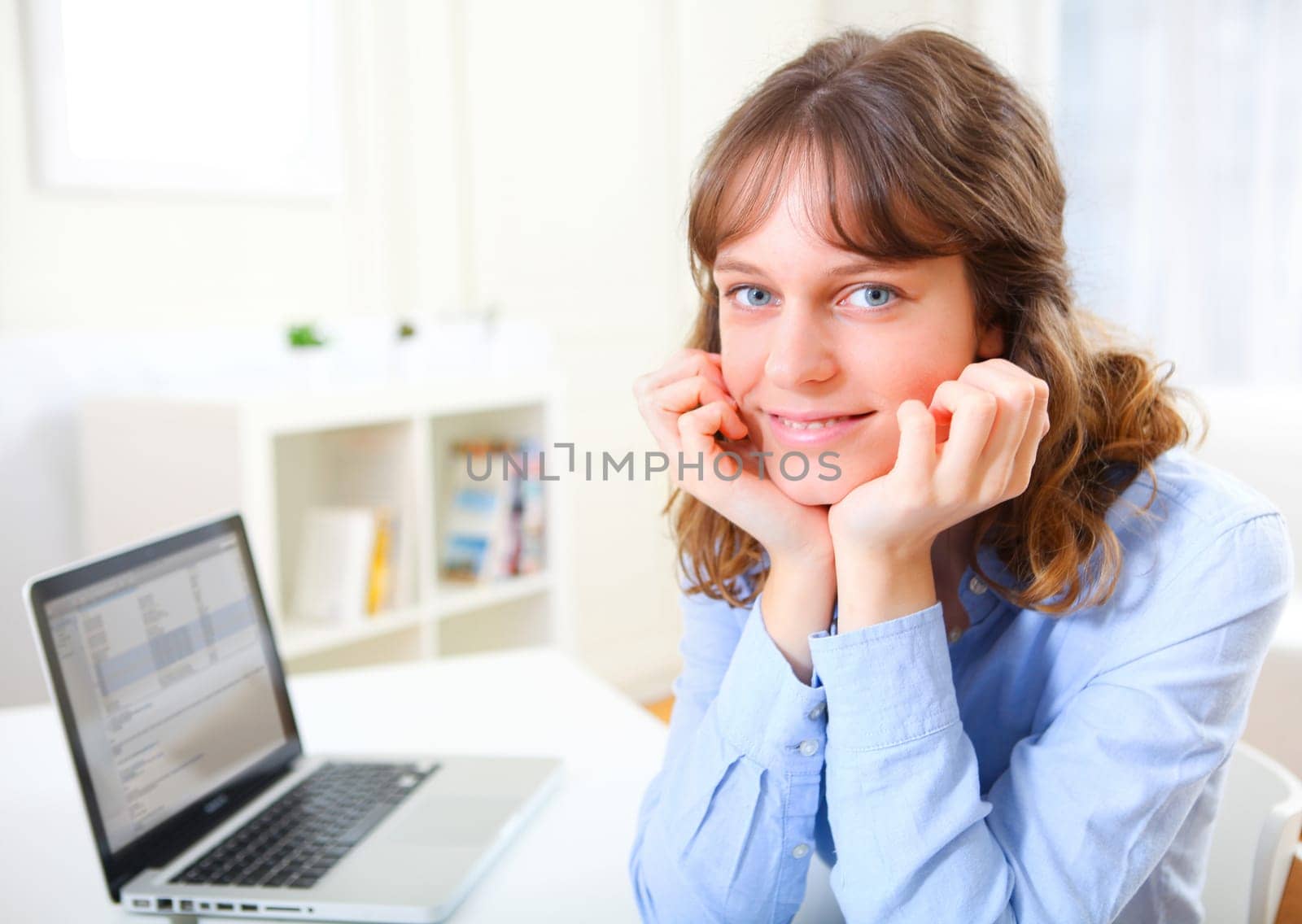 View of a young smiling business woman at work