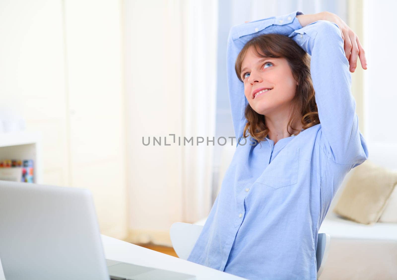 View of a young smiling business woman relaxing at work