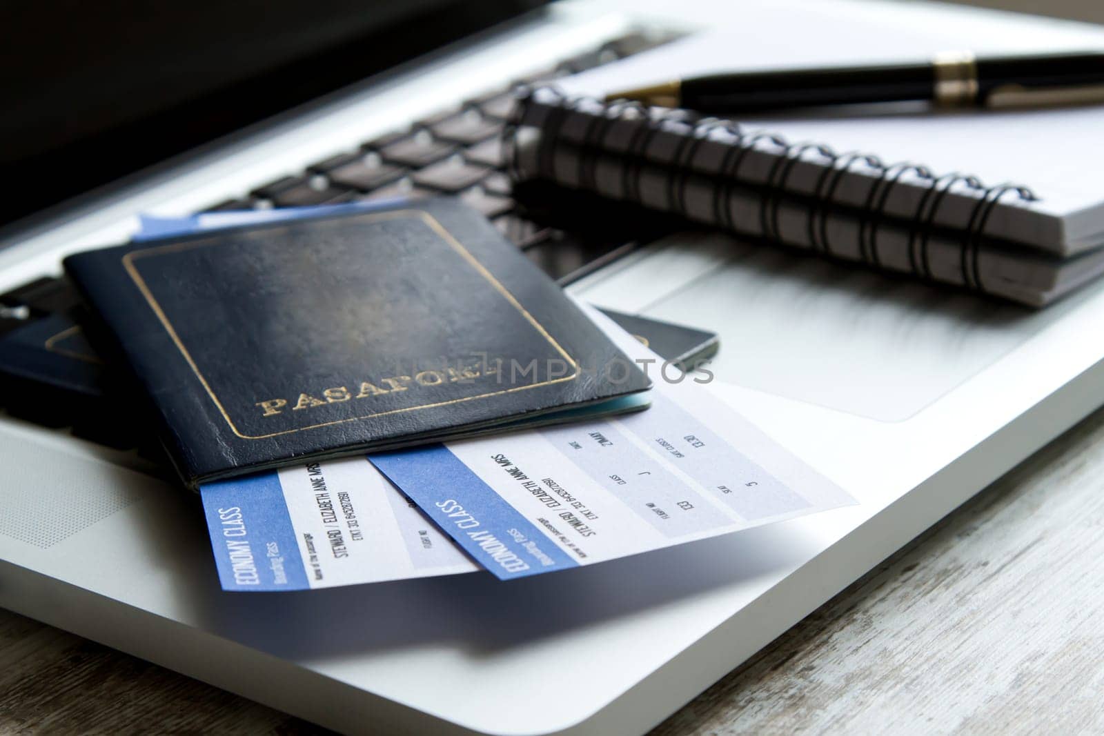 Airline tickets over the keyboard of a laptop.