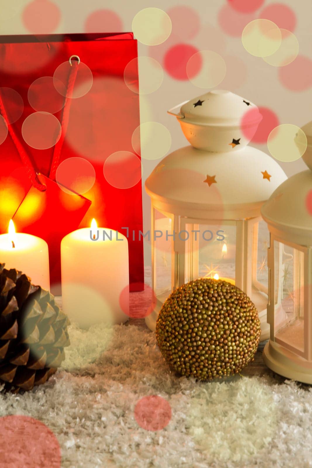 Christmas setting with candles, pine cones, shopping bags and baubles..