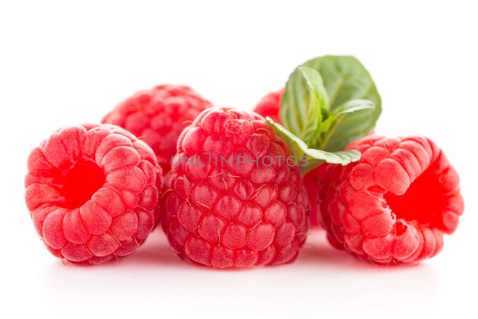 Raspberries with leaves isolated on white background