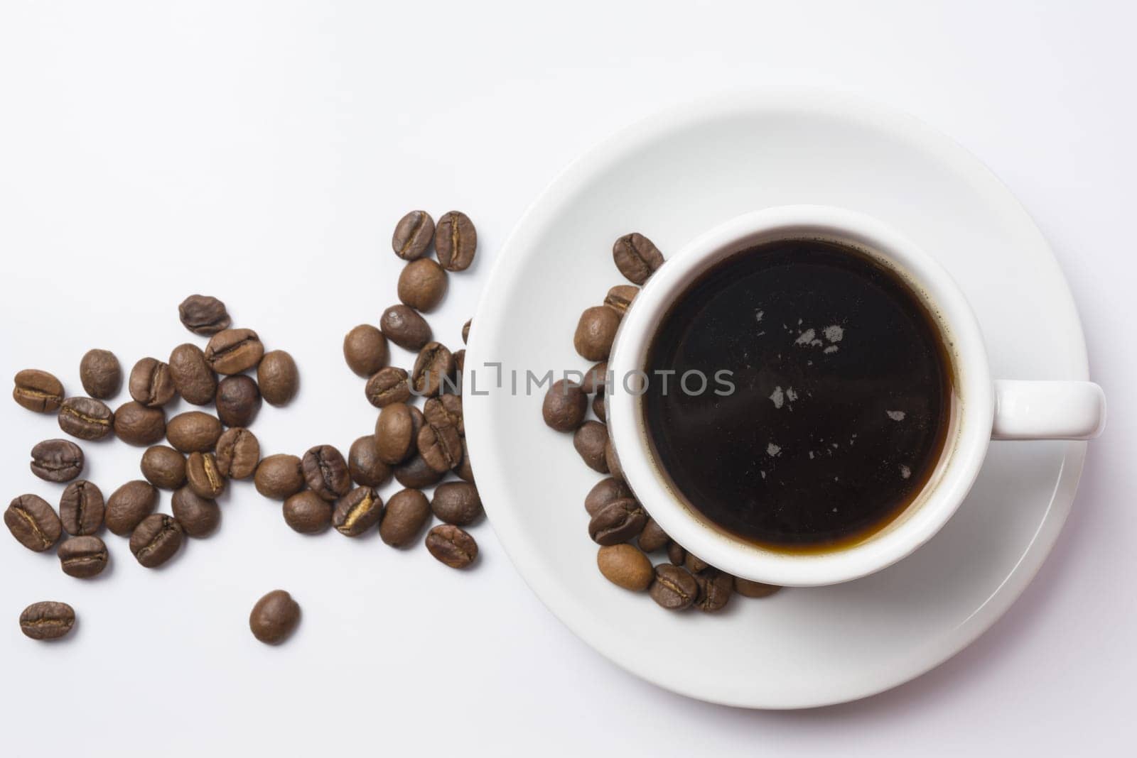 Top view, traditional cup of black coffee with beans over white background. Clipping path included, so you can easily copy and paste it on your own design.