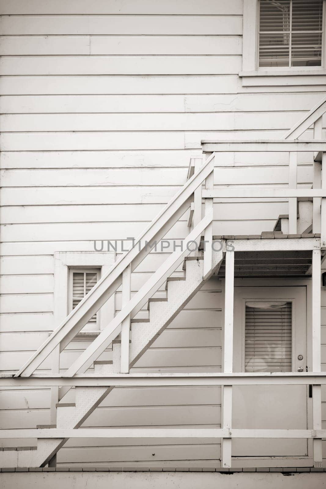 A wooden staircase at a house with board cladding.