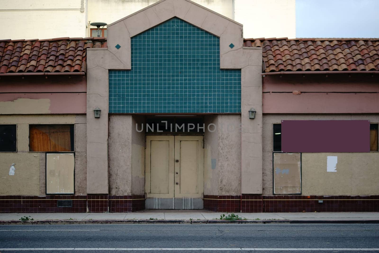A run-down theatre with snaked windows and a yellowed facade.