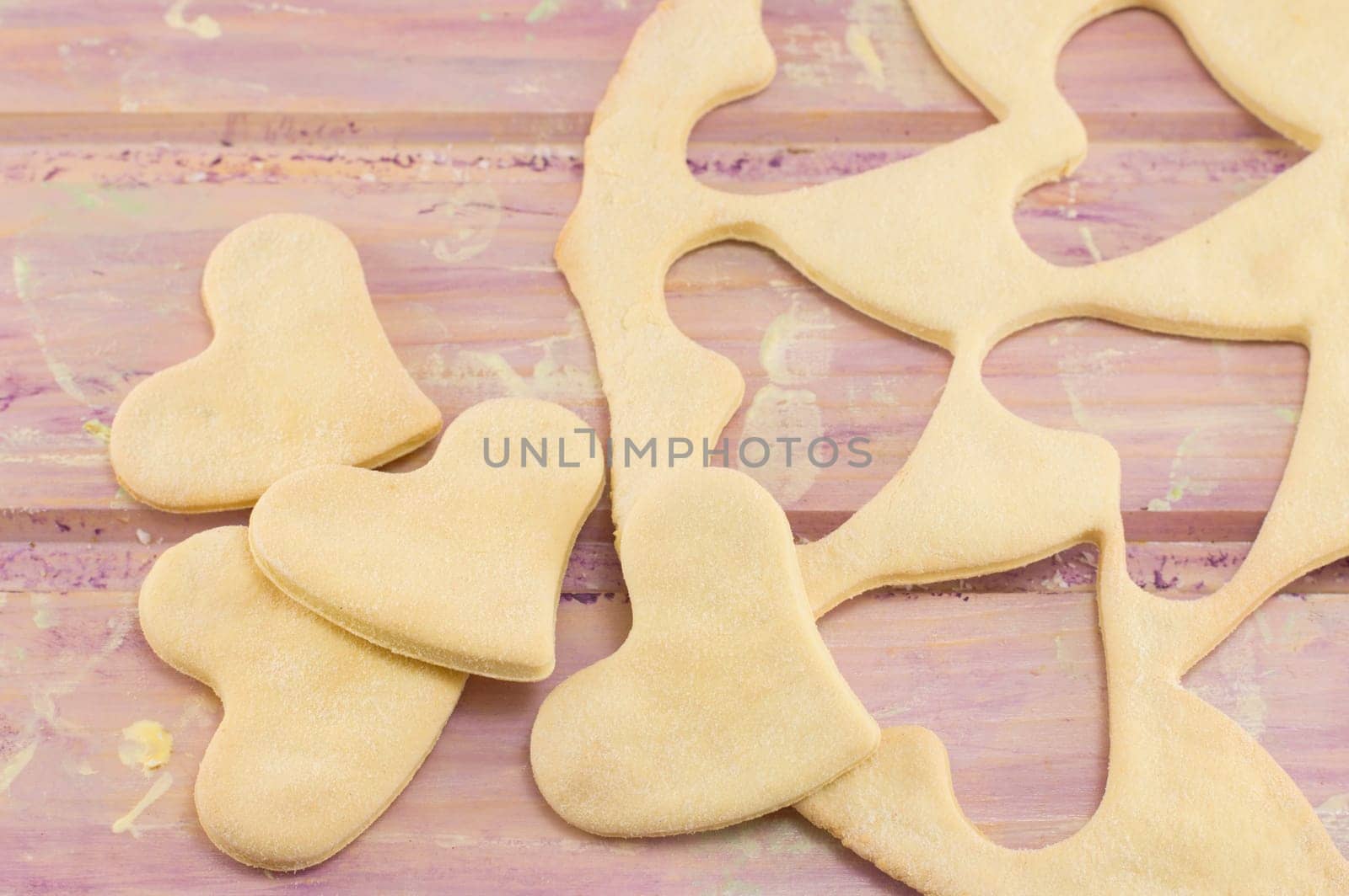 dough with hearts cut out on a wooden table