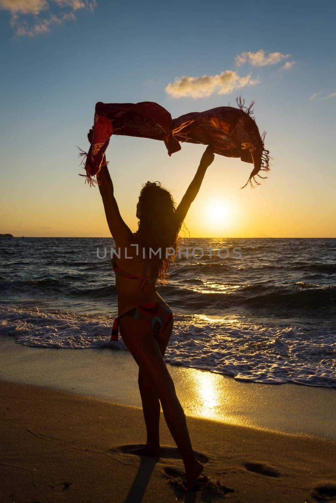 Woman on the beach at sunset