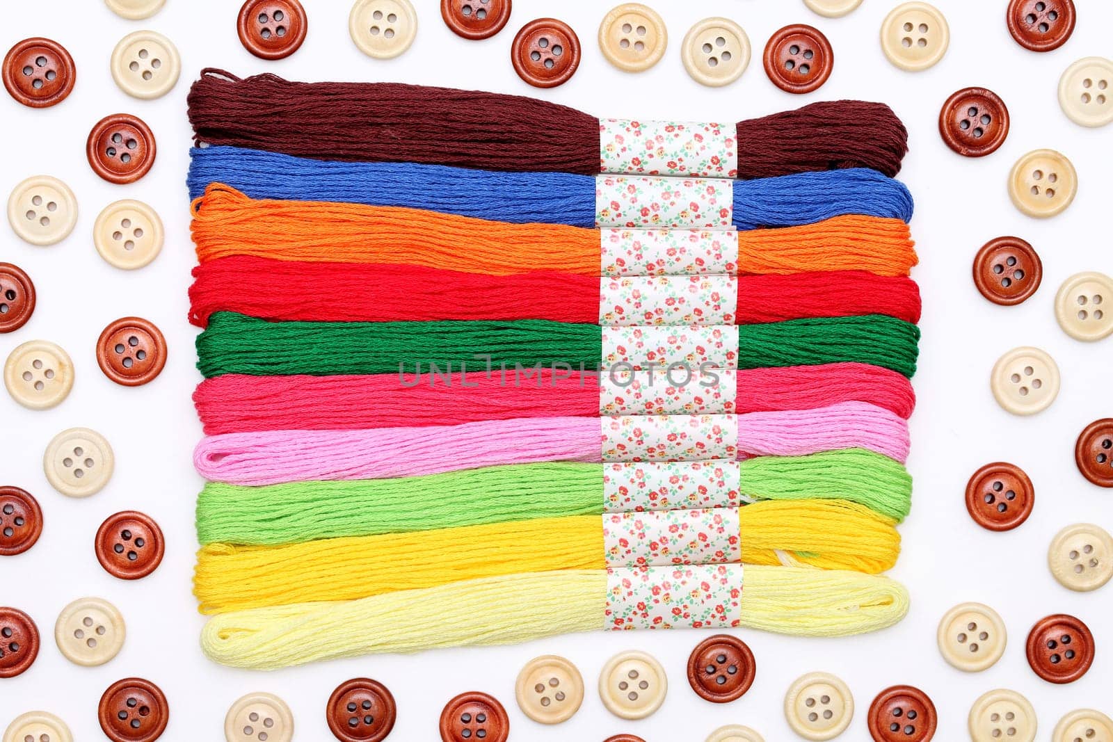 Sewing buttons and threads on white background