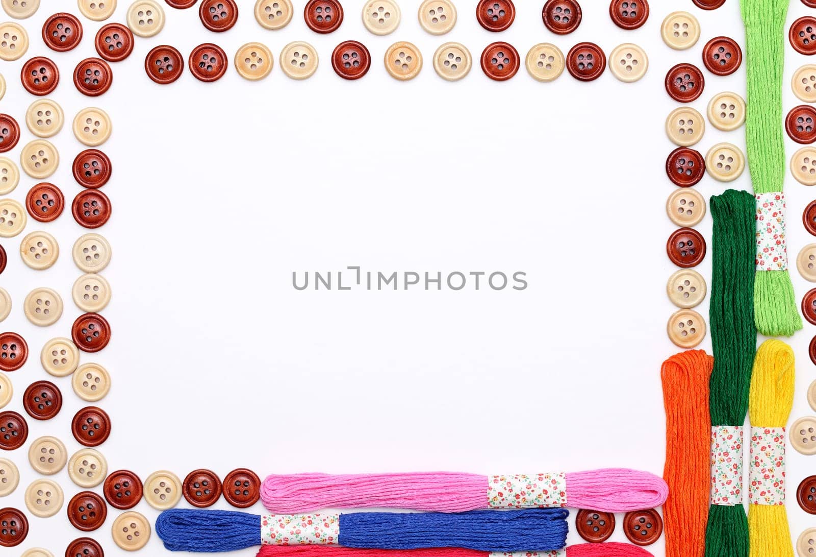 Sewing buttons and threads frame on white background