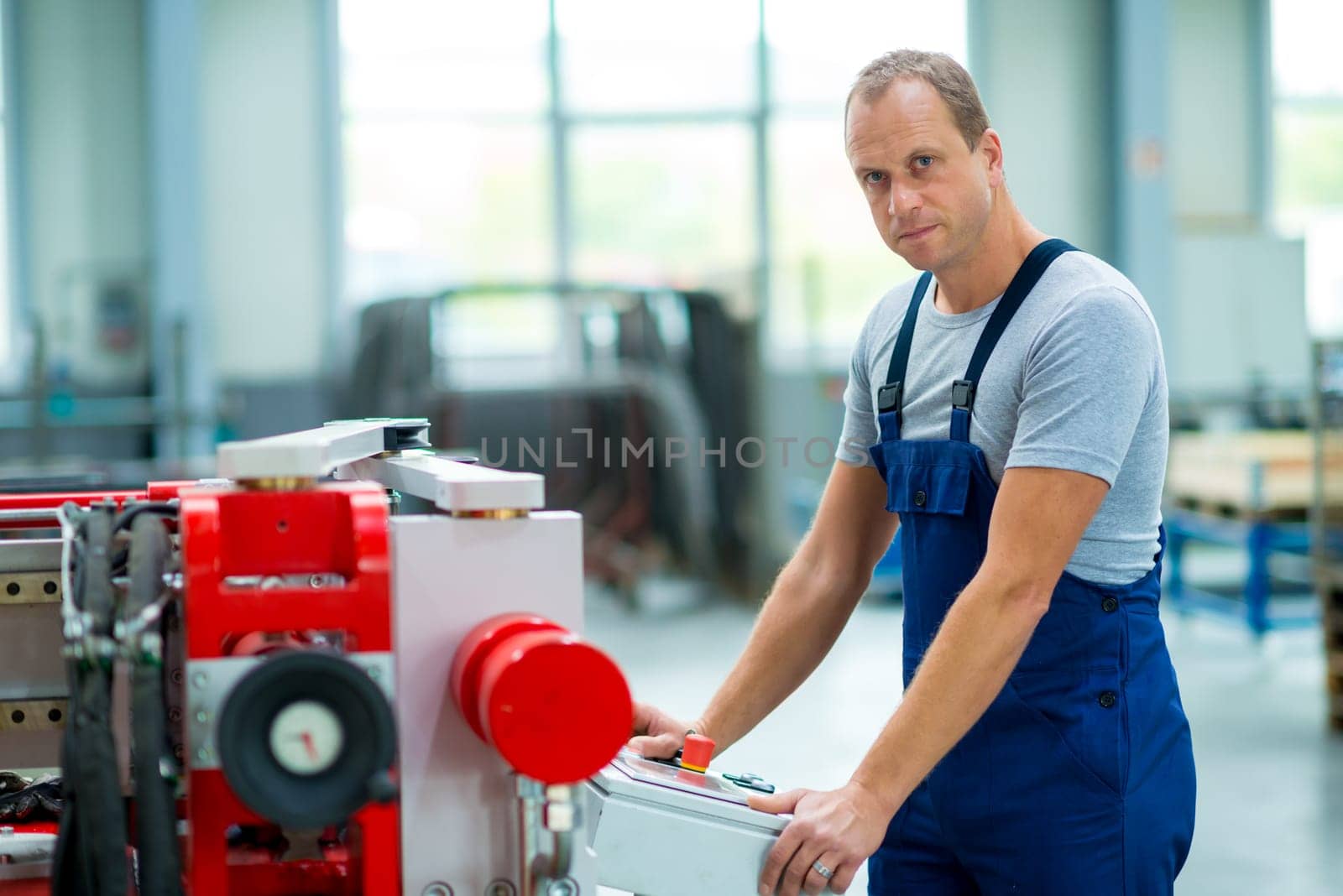 young worker in factory using machine
