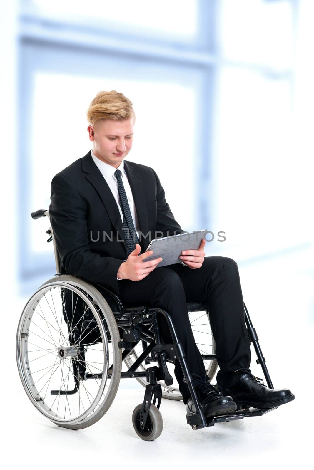 portrait of a young businessman in a wheelchair with tablet computer