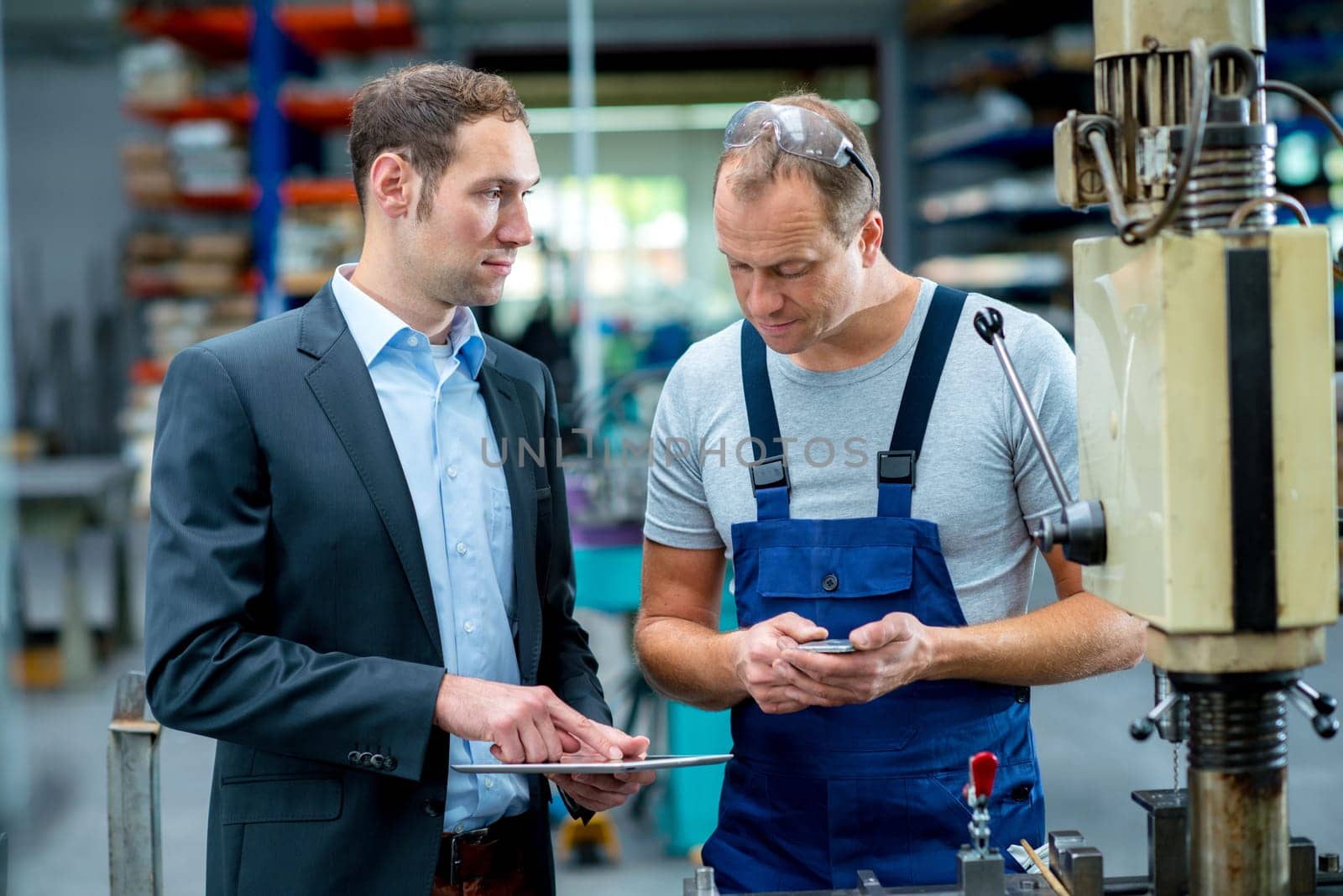 in the factory- young boss and worker in conversation