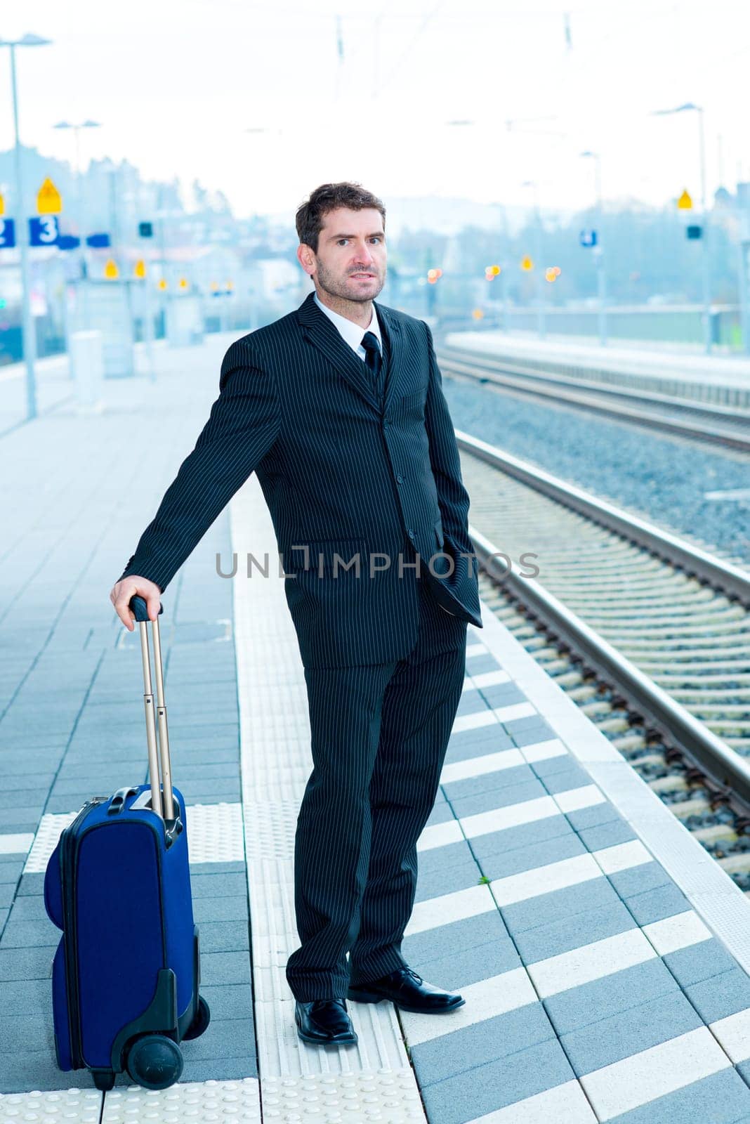businessman in dark suit on railroad station