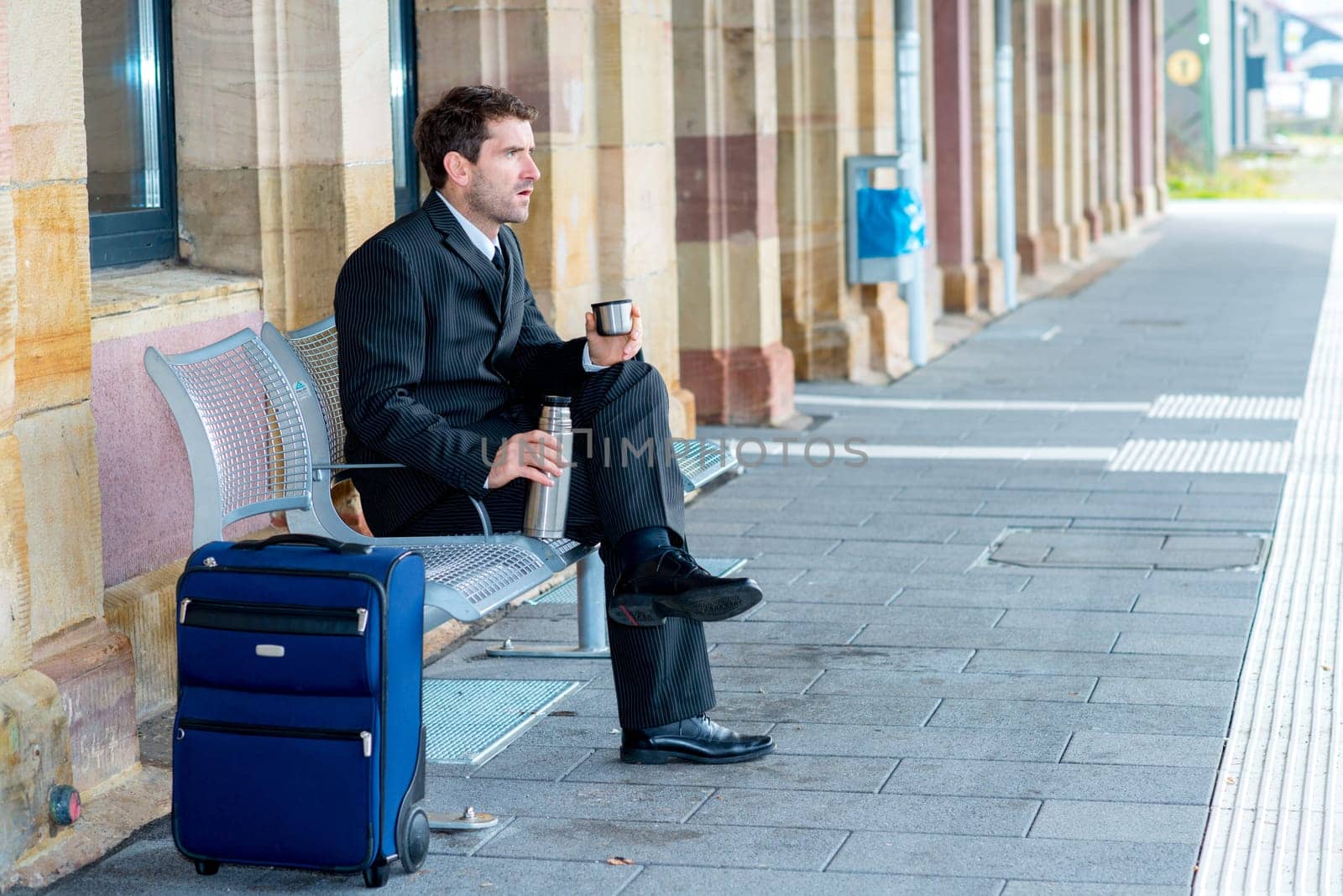 businessman on trip sitting on a bench and has a break